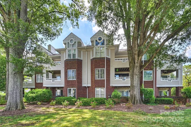 a front view of a house with yard and trees around