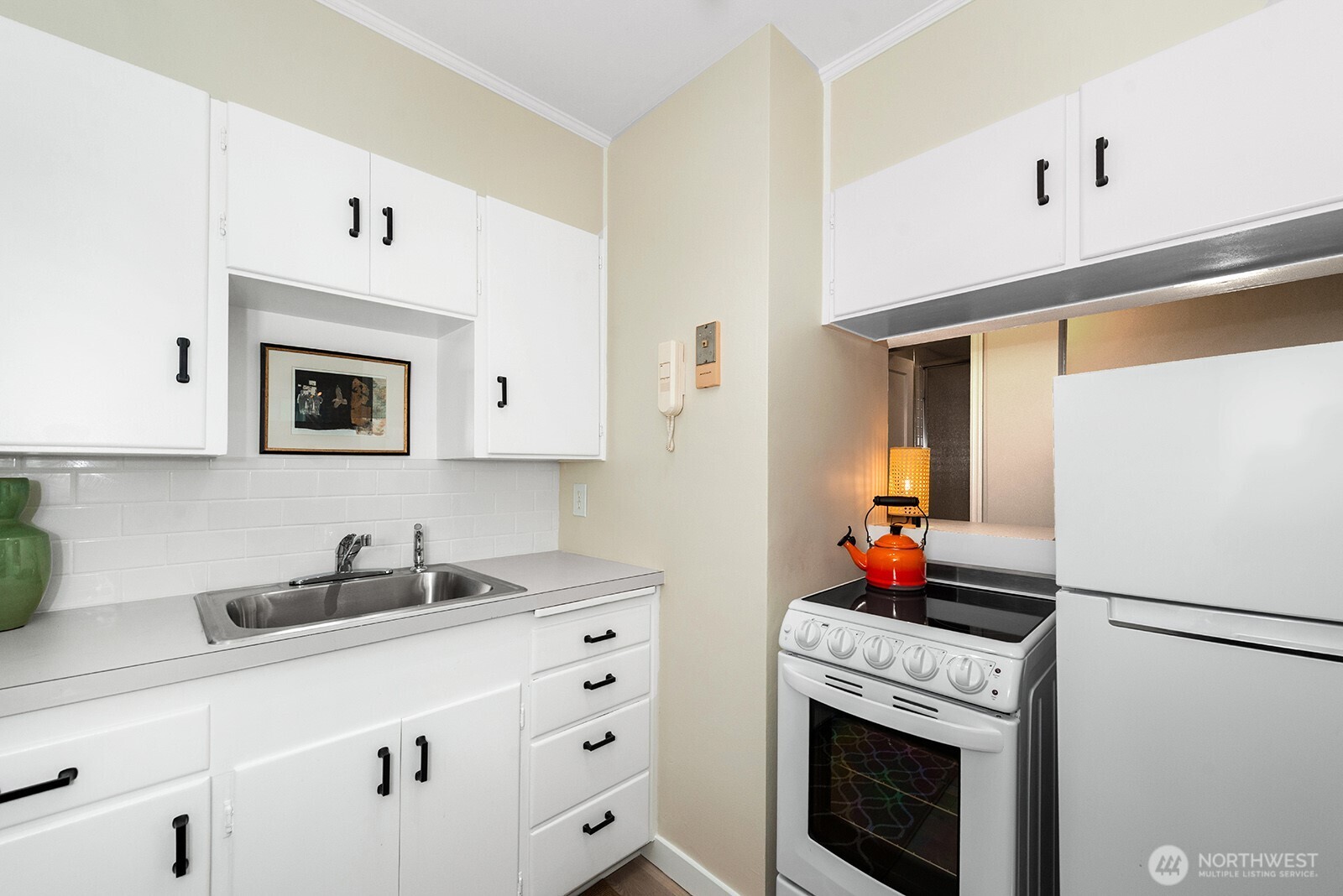 4407 Southwest Alaska Street, Unit 11 Seattle, WA 98116 - Photo 8 of 24 a kitchen with cabinets a sink and a refrigerator