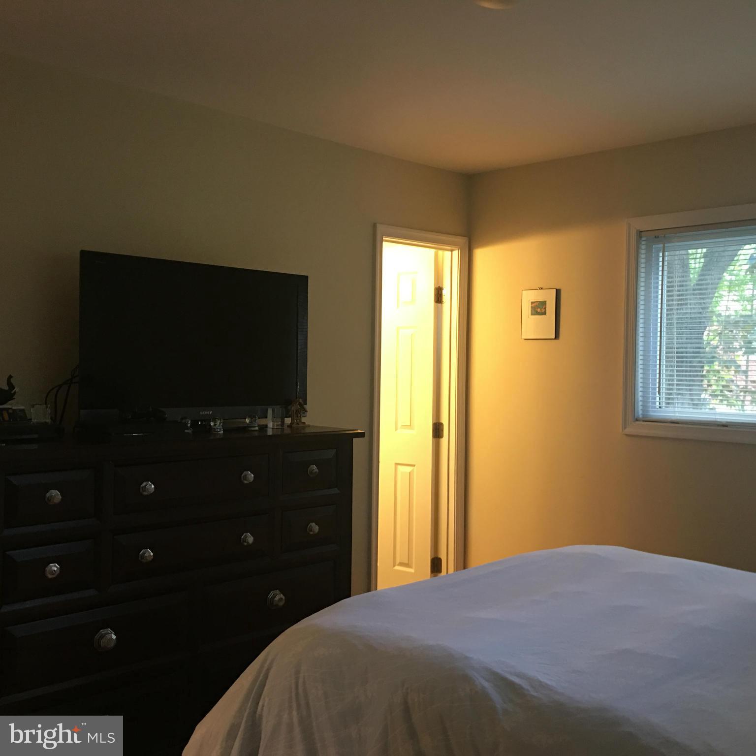 13306 Lydia Street Silver Spring, MD 20906 - Photo 13 of 30 a bedroom with a bed and a flat tv screen on dresser