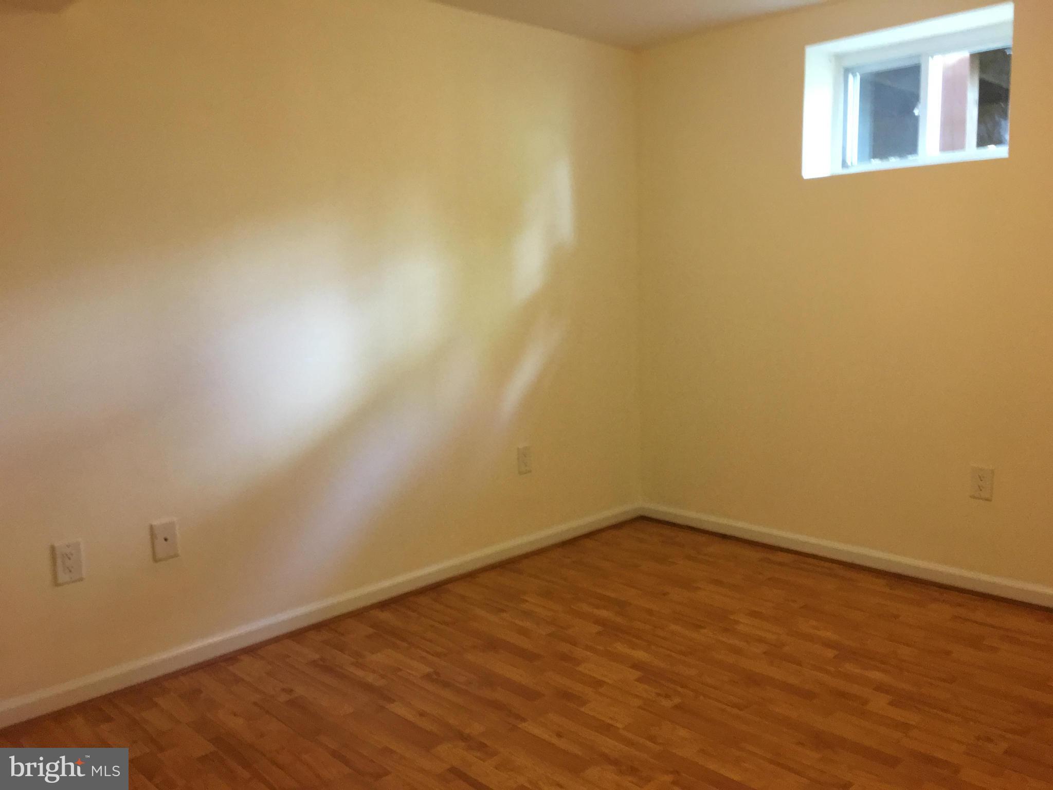 13306 Lydia Street Silver Spring, MD 20906 - Photo 25 of 30 a view of an empty room with wooden floor and a window