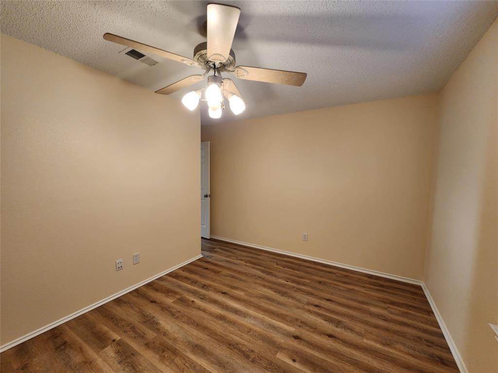 2413 Timber Ridge Lane Flower Mound, TX 75028 - Photo 31 of 32 Room featuring wood-finish flooring, a ceiling fan with integrated lighting, and neutral wall tones