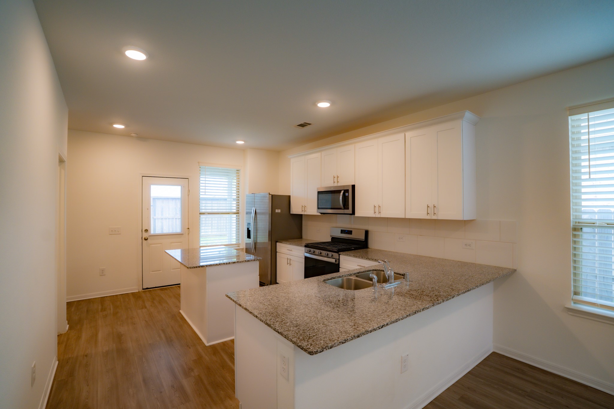 16126 Elbridge Court Conroe, TX 77302 - Photo 3 of 15 a kitchen with a sink stove and microwave