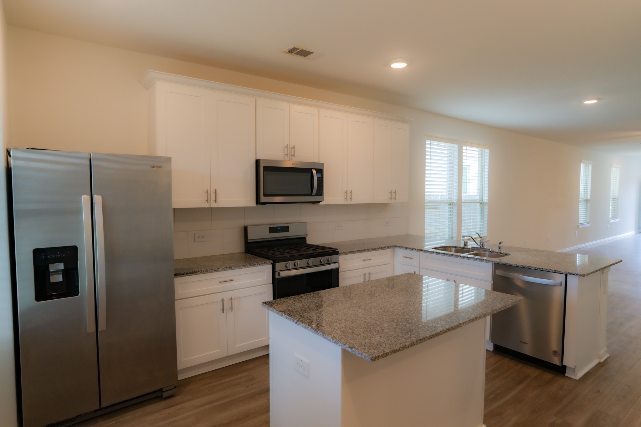 16126 Elbridge Court Conroe, TX 77302 - Photo 4 of 15 a kitchen with kitchen island granite countertop a sink appliances and cabinets