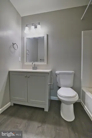 a bathroom with a toilet sink and mirror