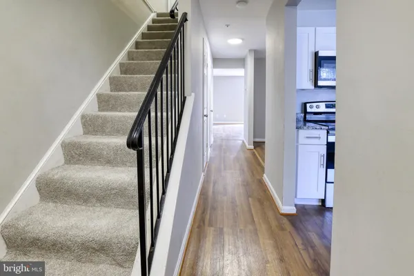 a view of a hallway with wooden floor and staircase