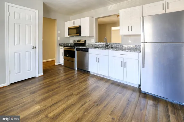 a kitchen with a refrigerator sink and wooden floor