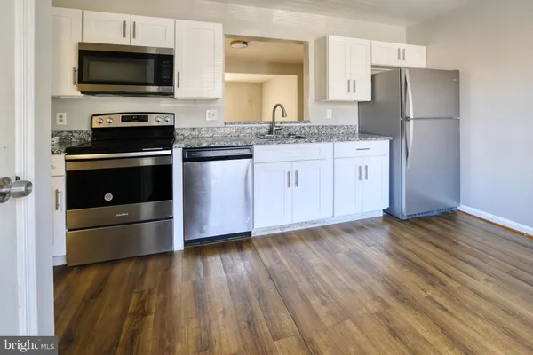 a kitchen with a sink a microwave a stove and refrigerator
