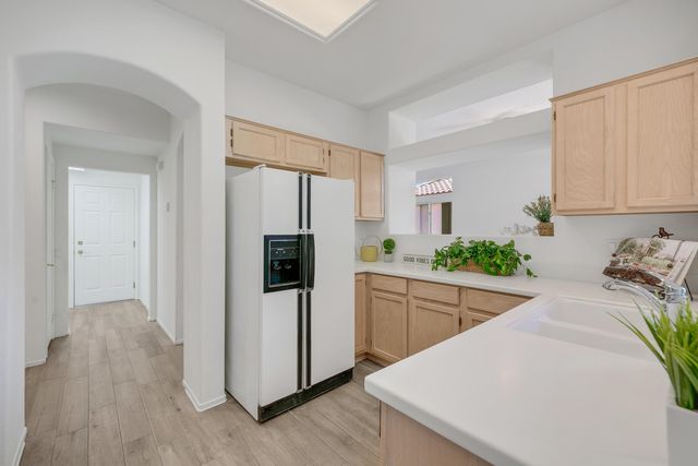 a kitchen with stainless steel appliances a refrigerator sink and wooden floor