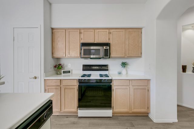 a kitchen with granite countertop white cabinets and stainless steel appliances