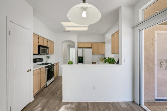 a kitchen with stainless steel appliances granite countertop a refrigerator a stove top oven a sink and dishwasher