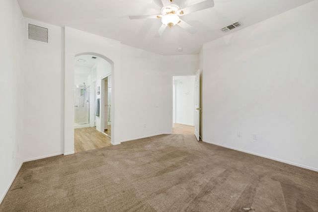 a view of an empty room with a chandelier fan
