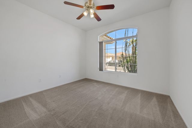 an empty room with windows and fan