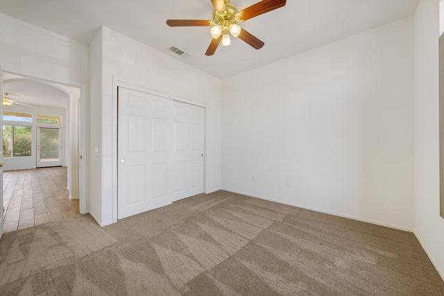 an empty room with windows and fan