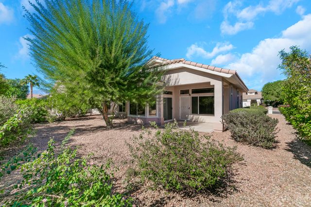 a view of a house with backyard and sitting area