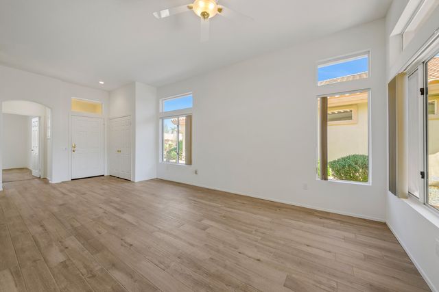 a view of an empty room with window and wooden floor