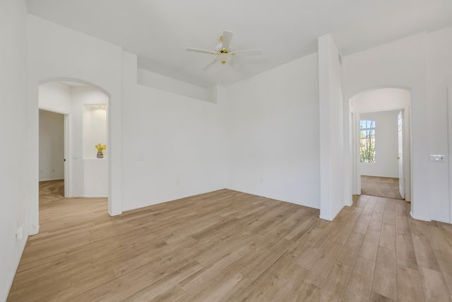 an empty room with wooden floor and a hallway