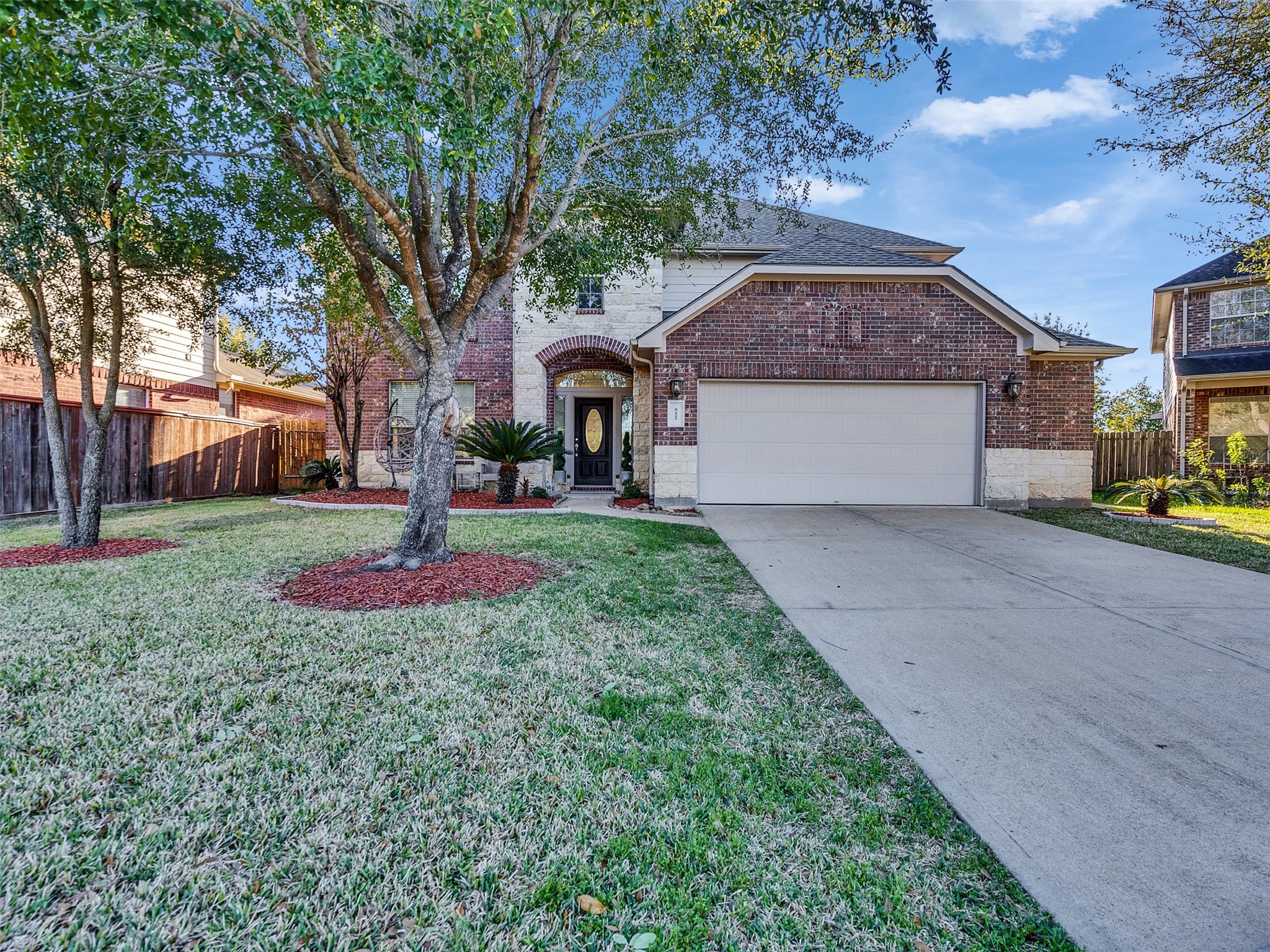522 Summer Mist Lane Rosenberg, TX 77469 - Photo 35 of 36 Multi-tonal red brick paired with white stone accents and a neutral, modern garage door.