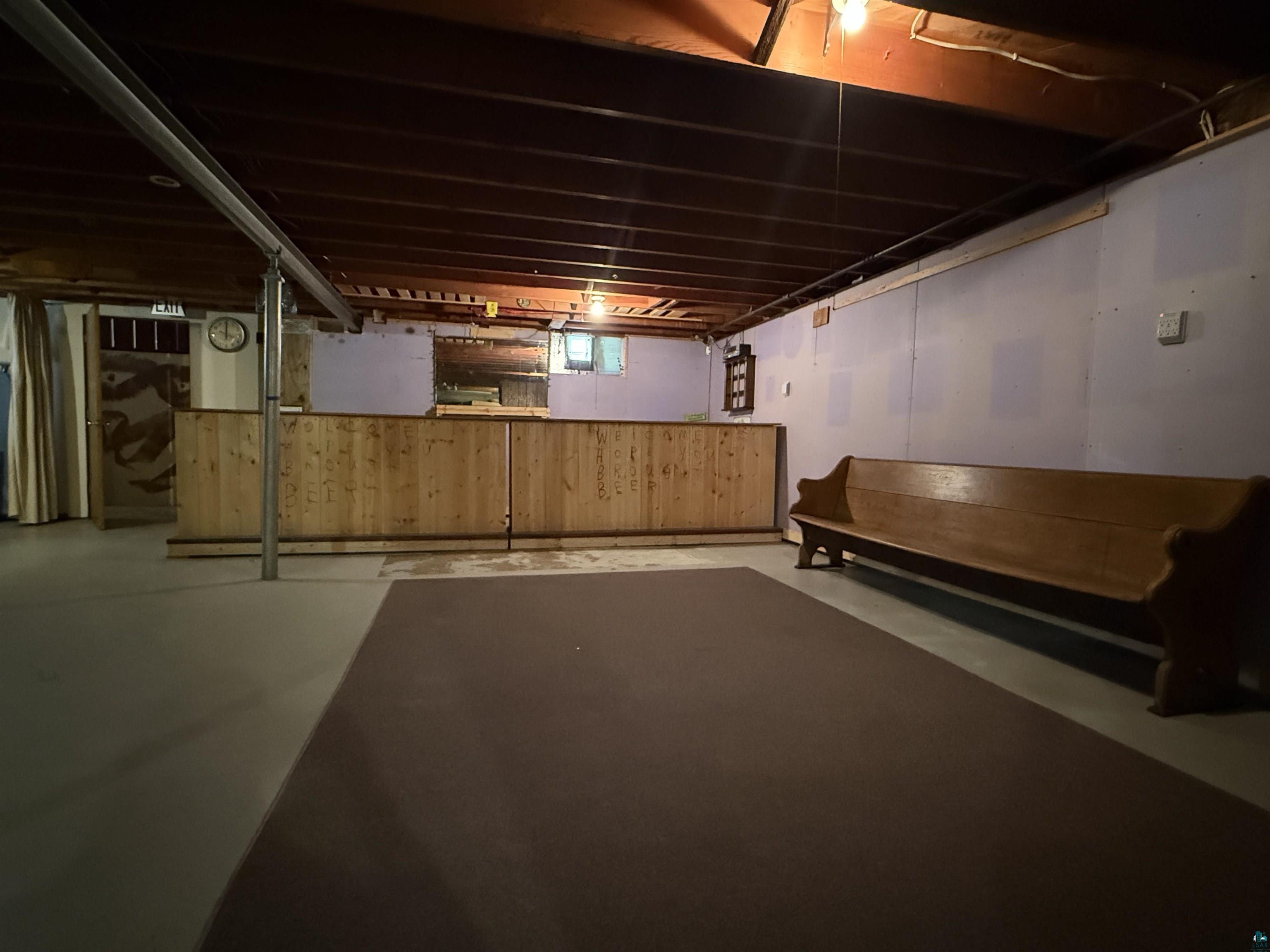 607 3rd Street Northeast Chisholm, MN 55719 - Photo 23 of 32 Basement area featuring an exposed ceiling, wood-paneled partition, and light purple walls