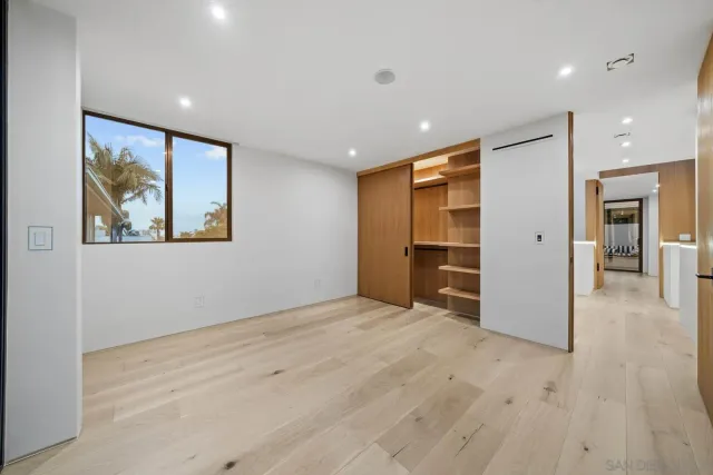 a bedroom with a bed tv and a large mirror