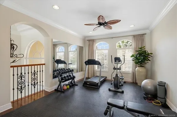 an empty room with windows and ceiling fan