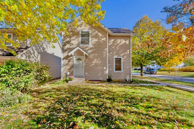 a large tree in front of a house with a yard