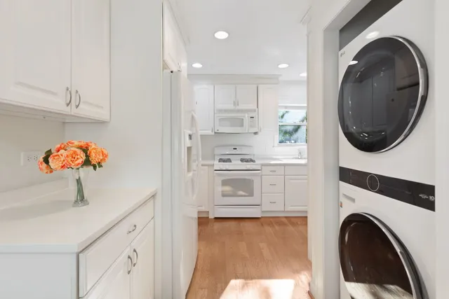 a view of a kitchen with stainless steel appliances cabinets a washer and dryer