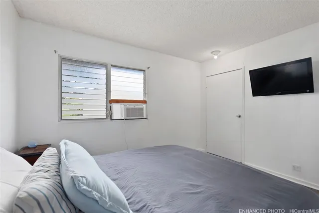 a bedroom with a bed and a flat screen tv
