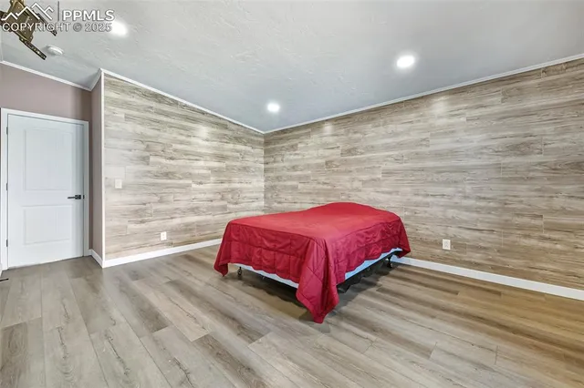 a spacious bedroom with a bed and wooden floor