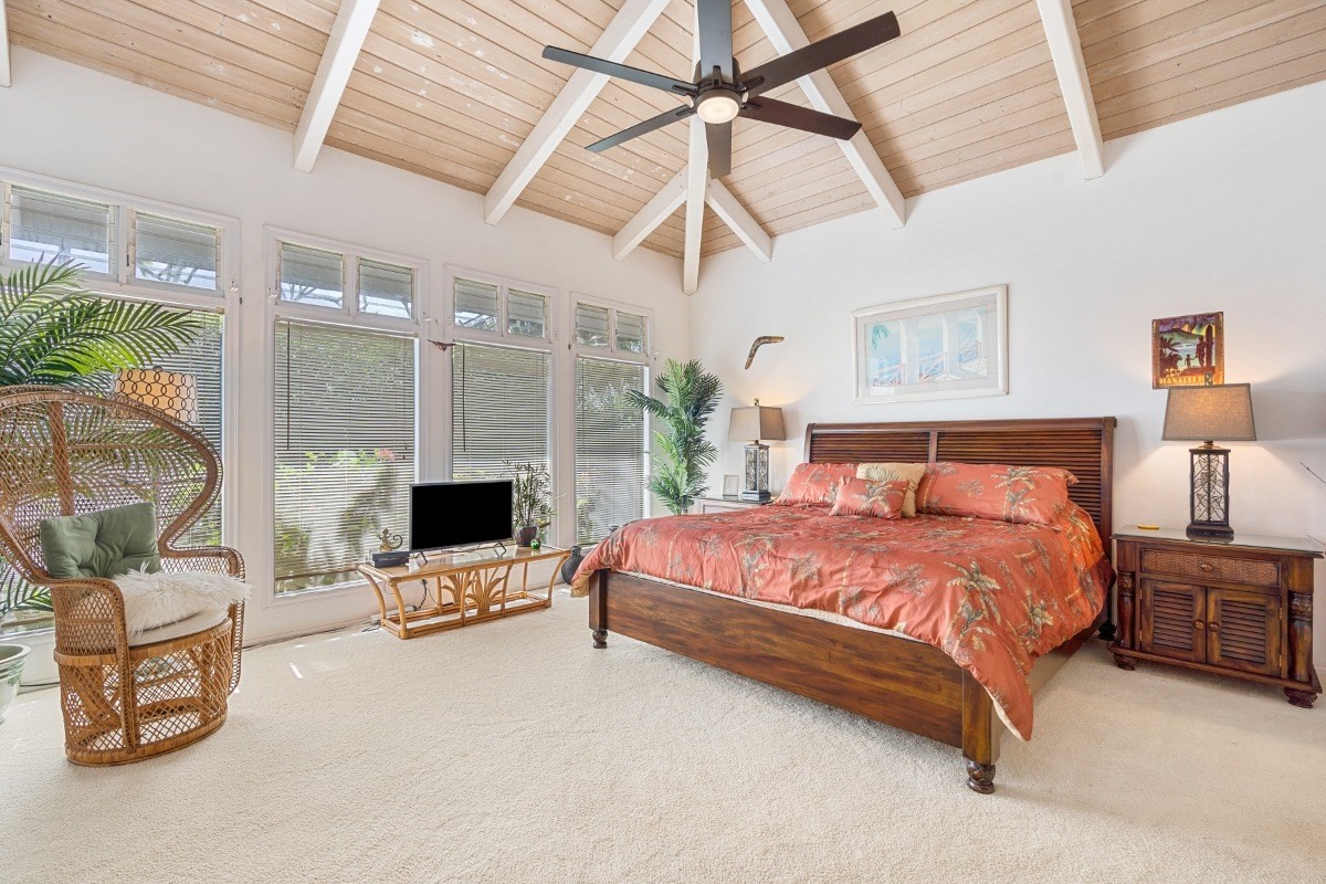 3791 Punahele Road Princeville, HI 96722 - Photo 12 of 30 a spacious bedroom with a bed a table and flat screen tv