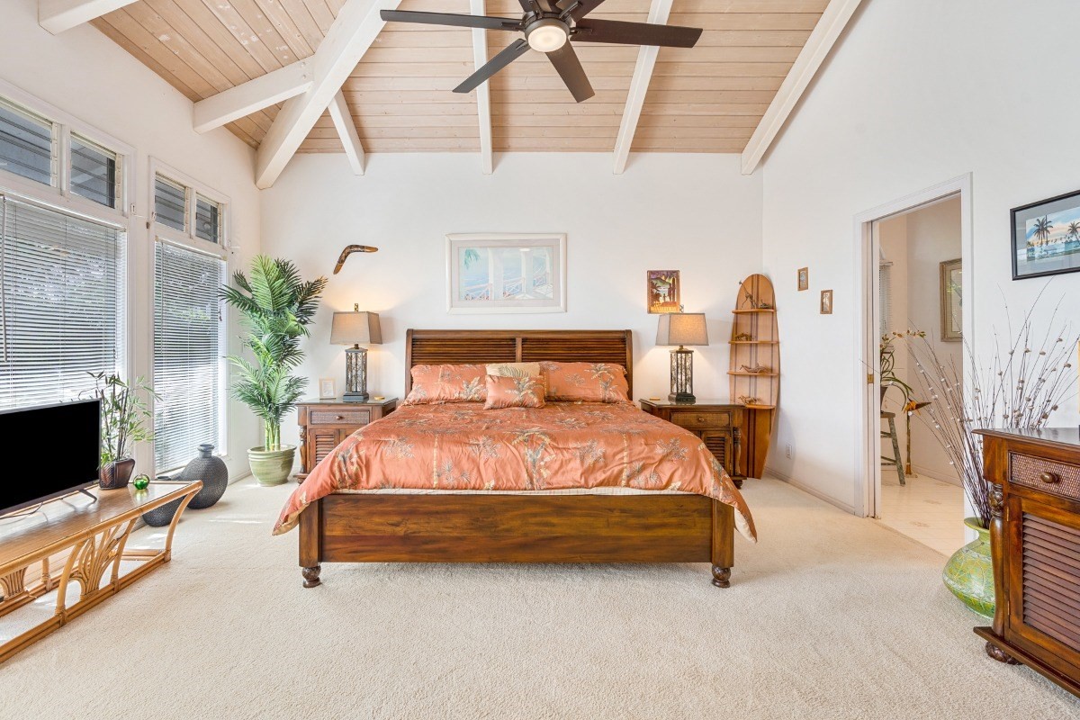 3791 Punahele Road Princeville, HI 96722 - Photo 13 of 30 a spacious bedroom with a bed a couch and a fireplace