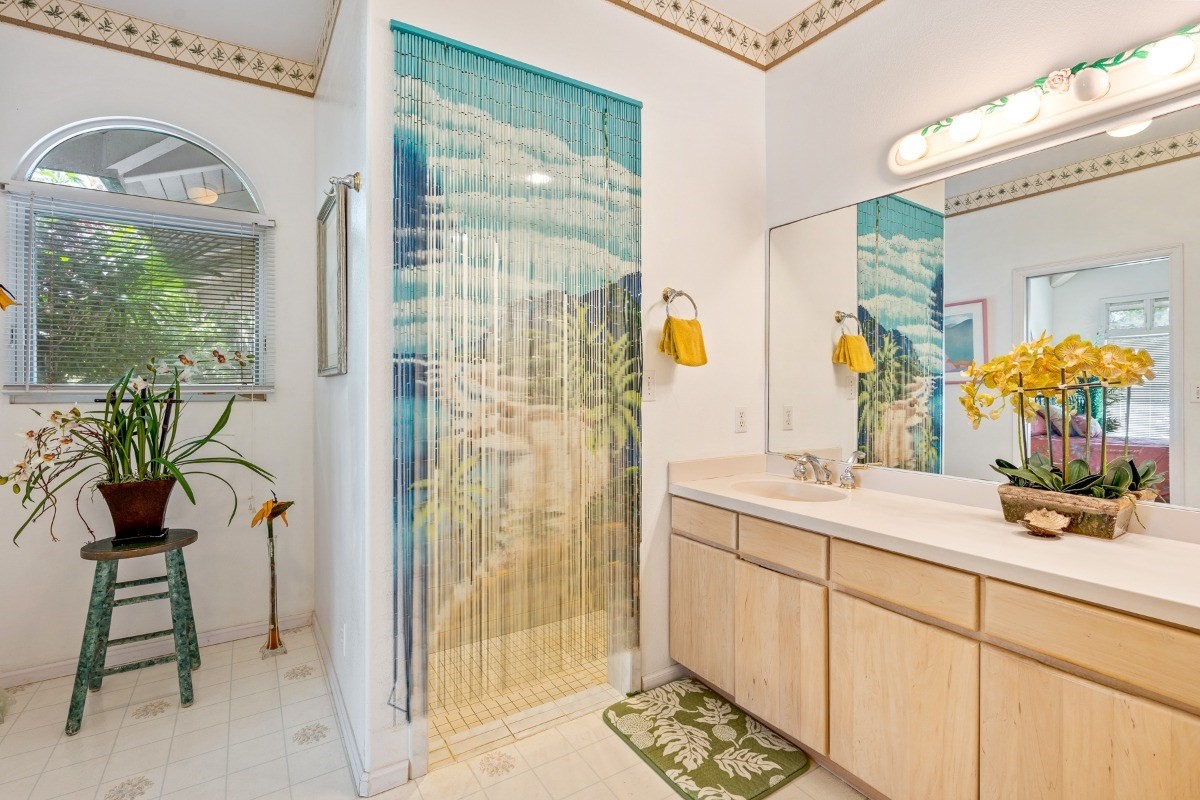 3791 Punahele Road Princeville, HI 96722 - Photo 14 of 30 a bathroom with a granite countertop sink a mirror and shower