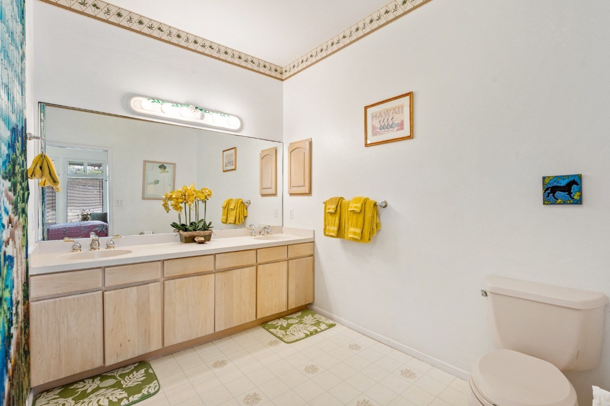 3791 Punahele Road Princeville, HI 96722 - Photo 15 of 30 a bathroom with a granite countertop sink a toilet and mirror