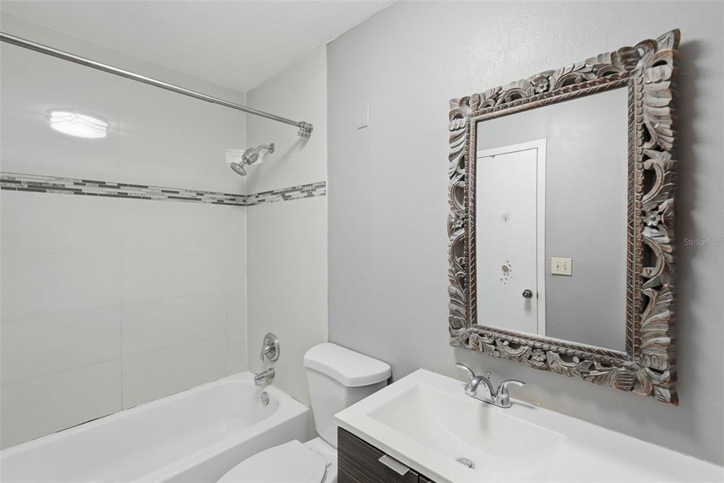 11709 Raintree Village Boulevard, Unit C Temple Terrace, FL 33617 - Photo 13 of 23 a bathroom with a sink mirror toilet and bathtub