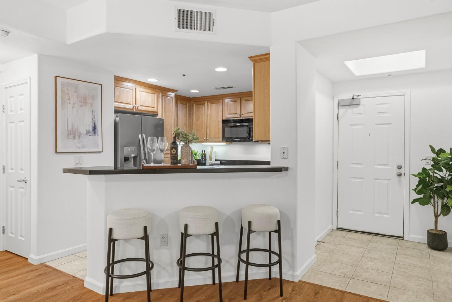 1390 Saddle Rack Street, Unit 223 San Jose, CA 95126 - Photo 8 of 36 a kitchen with stainless steel appliances kitchen island granite countertop a table chairs in it and wooden floors