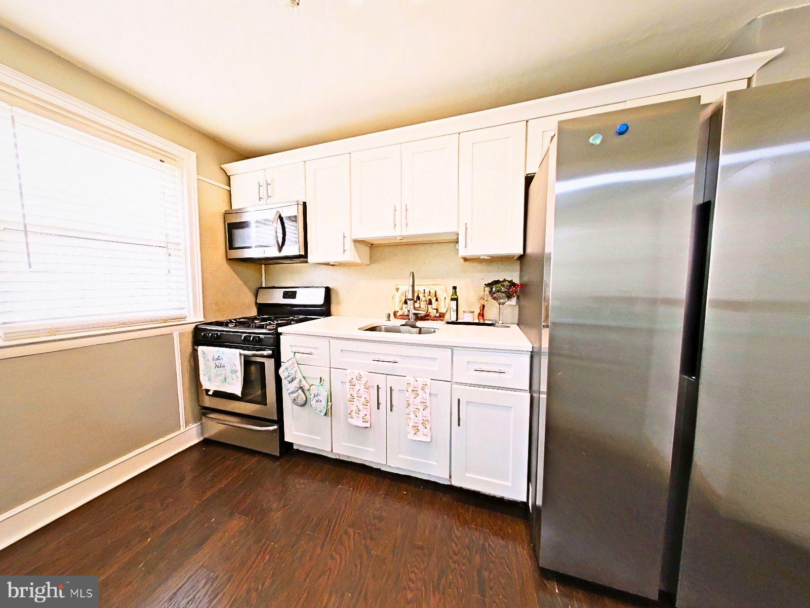 5844 Saul Street Philadelphia, PA 19149 - Photo 17 of 36 a kitchen with stainless steel appliances a refrigerator sink and cabinets