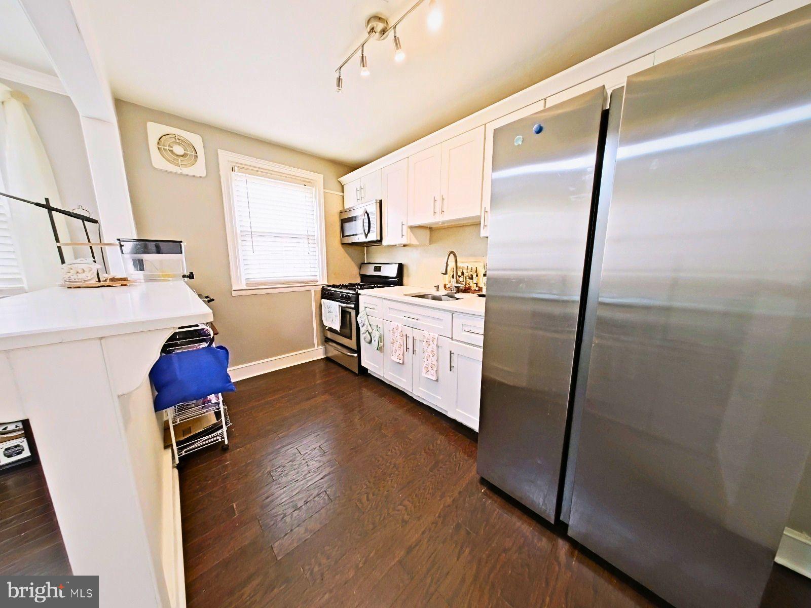 5844 Saul Street Philadelphia, PA 19149 - Photo 19 of 36 a kitchen with stainless steel appliances a refrigerator sink and wooden floor