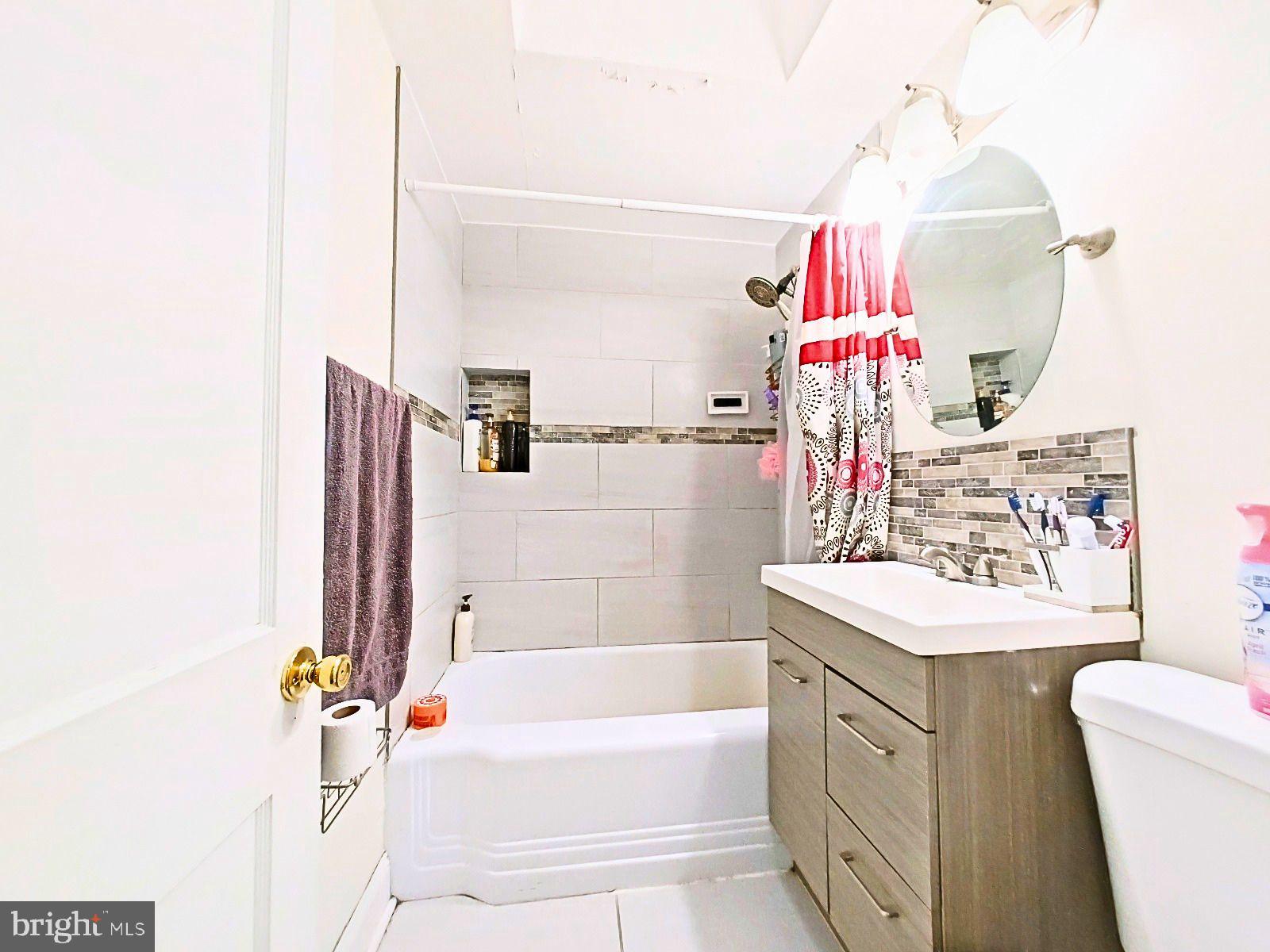 5844 Saul Street Philadelphia, PA 19149 - Photo 23 of 36 a bathroom with a sink mirror vanity and bathtub