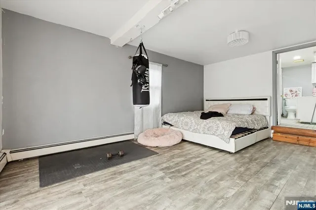 a living room with a bed furniture and a flat screen tv