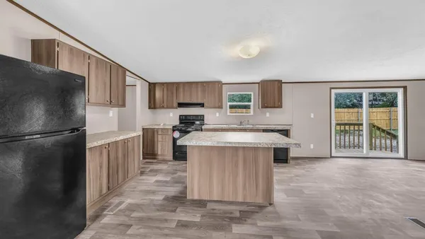 a kitchen with stainless steel appliances granite countertop a refrigerator a sink a stove a microwave and island