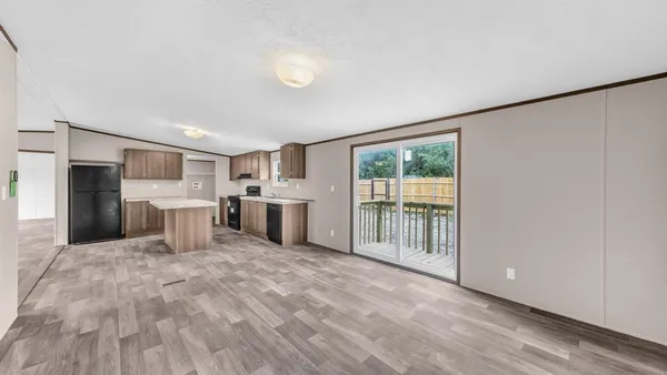 a large white kitchen with stainless steel appliances granite countertop a refrigerator oven a sink dishwasher and white cabinets with wooden floor