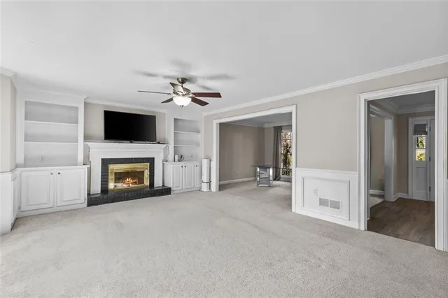 an empty room with chandelier fan and windows