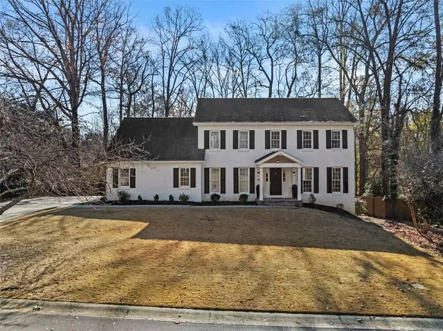 a front view of house with yard and trees around