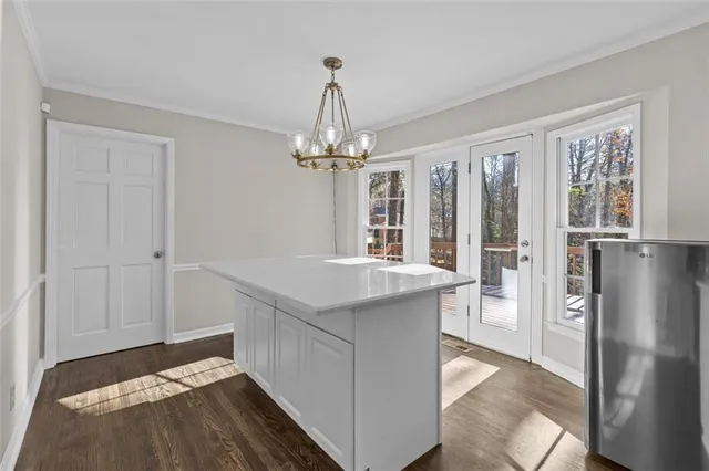 a view of an empty room with chandelier fan