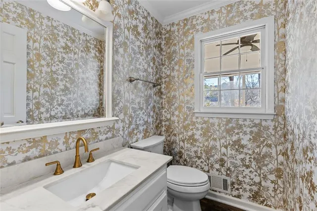 a bathroom with a granite countertop sink a toilet and a mirror