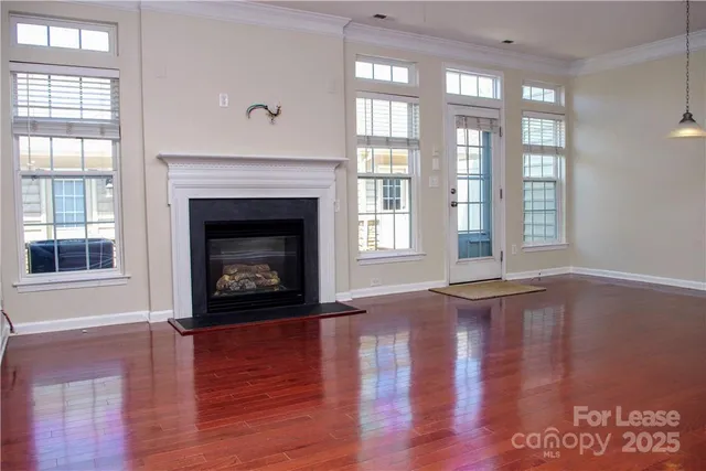 a living room with wooden floor and a fireplace