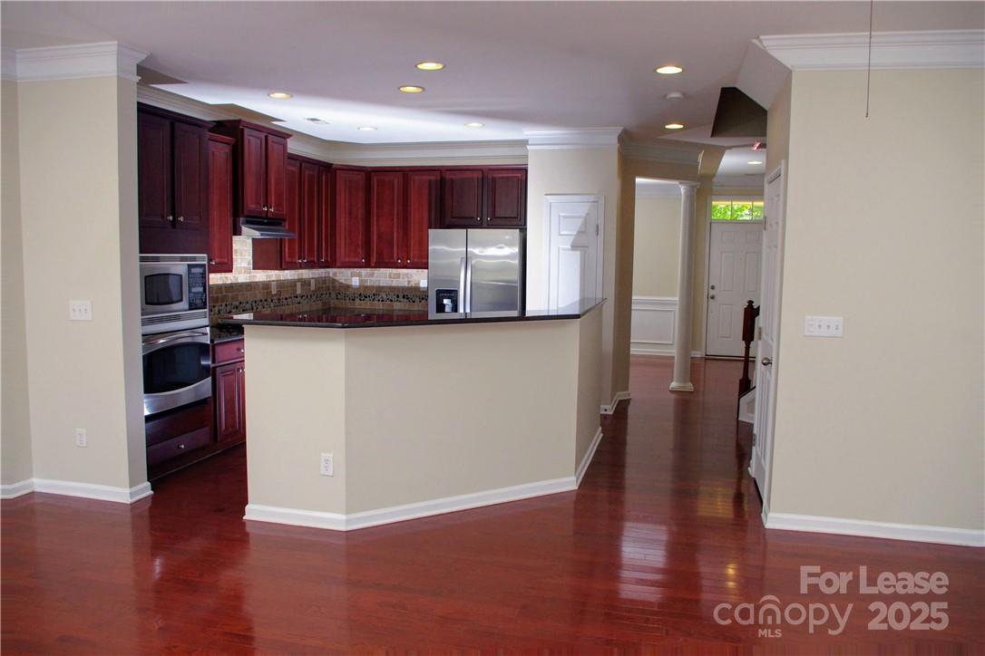 8339 Viewpoint Lane Cornelius, NC 28031 - Photo 10 of 30 a kitchen with stainless steel appliances granite countertop a refrigerator a sink and wooden floors
