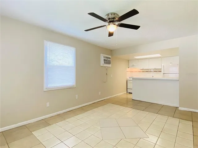 an empty room with a ceiling fan and window