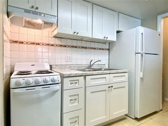 a kitchen with appliances a sink and cabinets