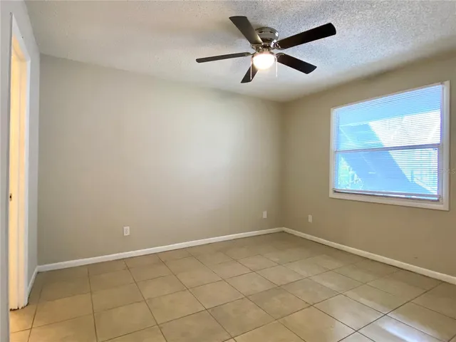 an empty room with a window and a fan
