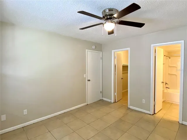 an empty room with closet and a chandelier fan
